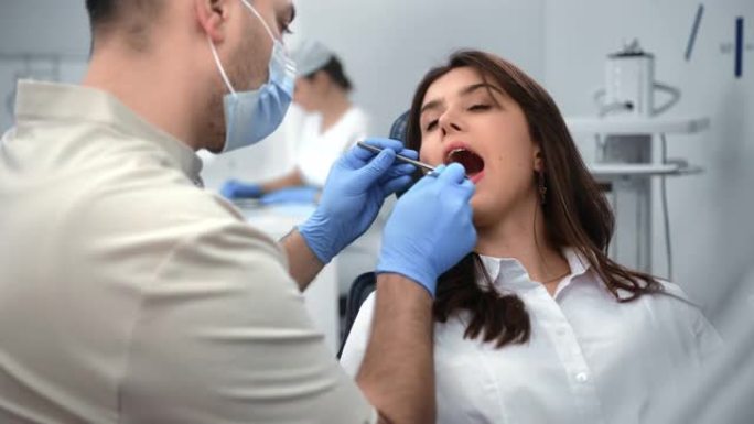 在诊所定期进行牙科体检时张口的女性患者