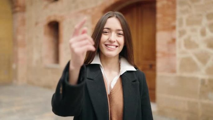 年轻的西班牙裔妇女微笑着自信地在大学里做手势