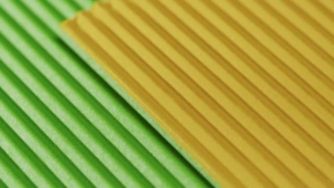 黄色和绿色的罗纹纸特写。纸板纹理背景的宏观拍摄。彩色壁纸