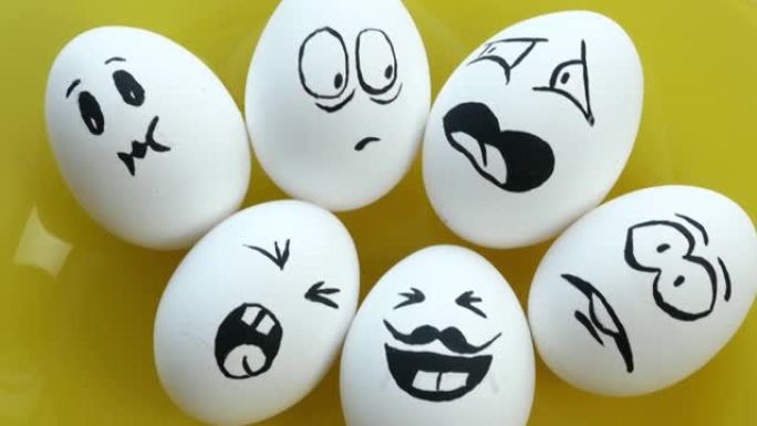 在黄色盘子上煮了白色的鸡蛋，带有有趣的情感面孔。恐惧，愤怒，蔑视，笑声，喜悦，惊讶，烦恼。复活节