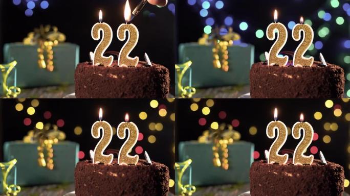 生日蜡烛22号放在桌子上的甜蛋糕上，距出生已有22年了。打火机上的火，吹灭节日蜡烛。