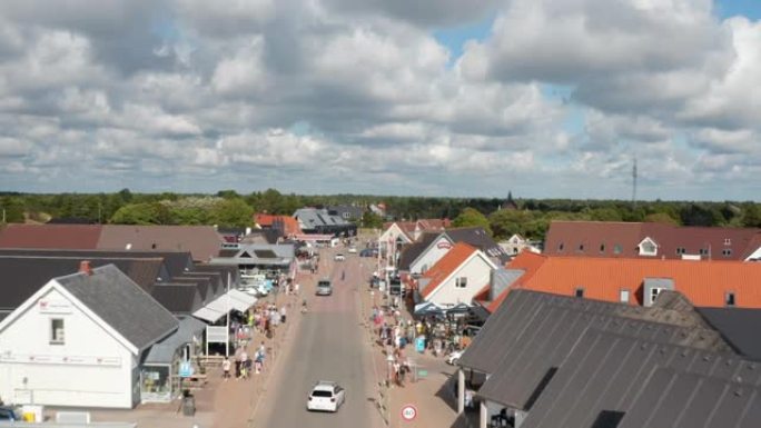 奥克斯比购物街的航拍画面。飞越在沿海小镇中心漫步的人们。暑假目的地。丹麦
