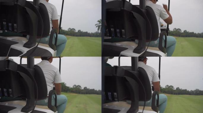 暑假期间，亚洲男子高尔夫球手在乡村俱乐部驾驶高尔夫球车。