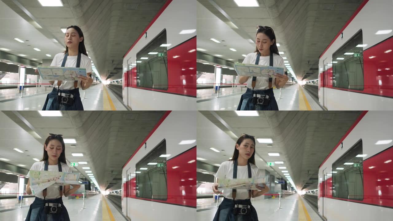 带相机的亚洲女游客在火车站搜索位置图。