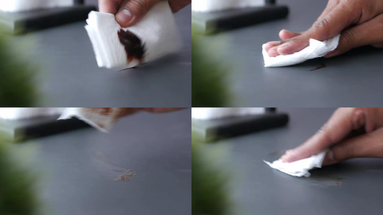 人手清洁巧克力洒在桌子上的特写