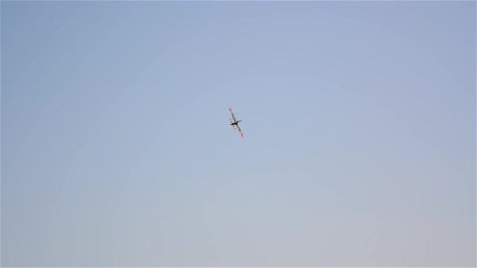 在蓝天上飞行的玩具飞机被热情的人从地面上驾驶