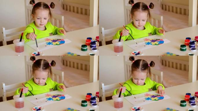 一个两岁的孩子用水彩颜料从不同的拼图中画出一颗五彩的心。
