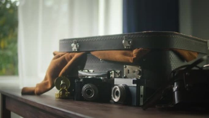 旧相机组成。古董照片设备收藏。老式老式相机的特写镜头放在桌子、手提箱和指南针上，用于旅行。