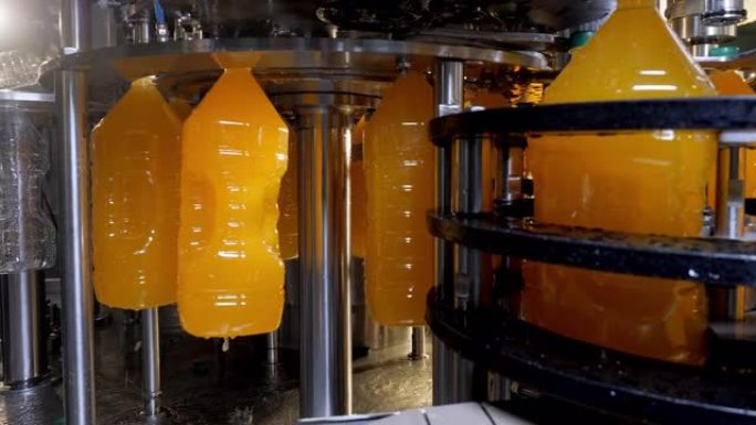 在工厂的自动输送线上装瓶天然橙汁。