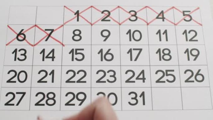 男人的手用红笔在纸质日历上写下6,7，8,9，第10天