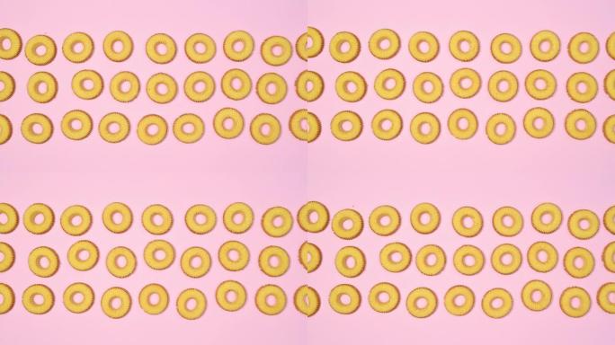 出现三列圆形饼干，并在柔和的粉红色主题上移动。停止运动
