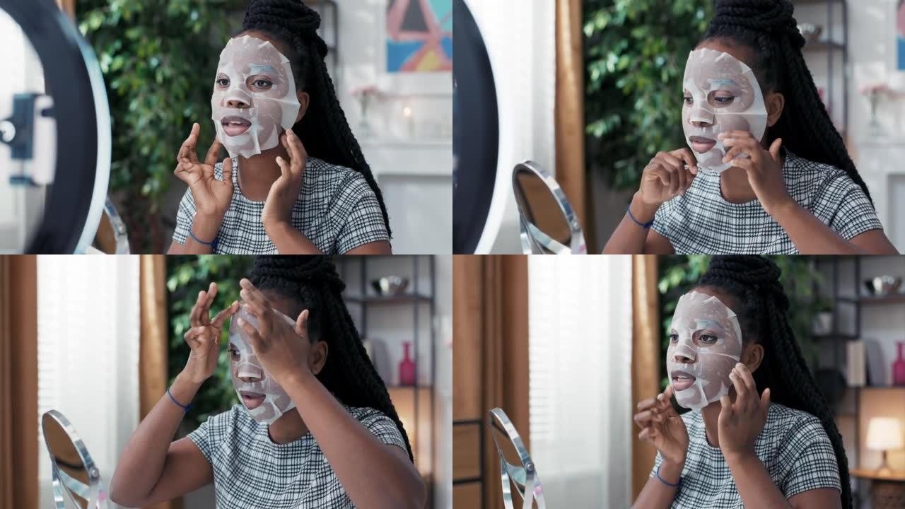 Influencer records美容教程将面膜应用于面部使用手机的环形灯，博客作者谈论皮肤护理用