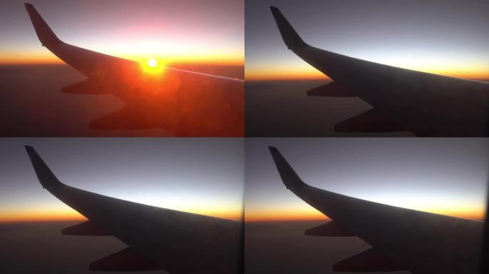 日出时飞机的机翼挡住了阳光。从飞机的窗户看。飞机在日落时飞行。乘飞机旅行。