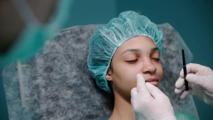 外科医生在隆鼻术前戴着手套在女孩的脸上画线条