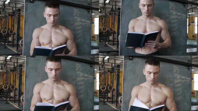肌肉发达的运动员在健身房的笔记本上写结果。运动，举重和保健概念