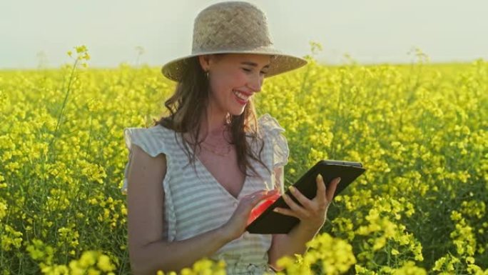 一个年轻女子在花丛中使用数码平板电脑的4k视频片段