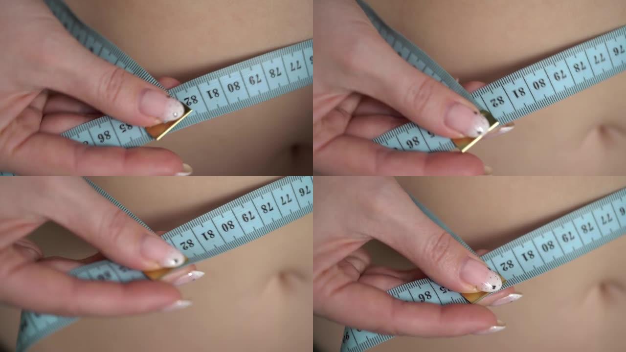 年轻女子用卷尺量腰围。减肥后的体型