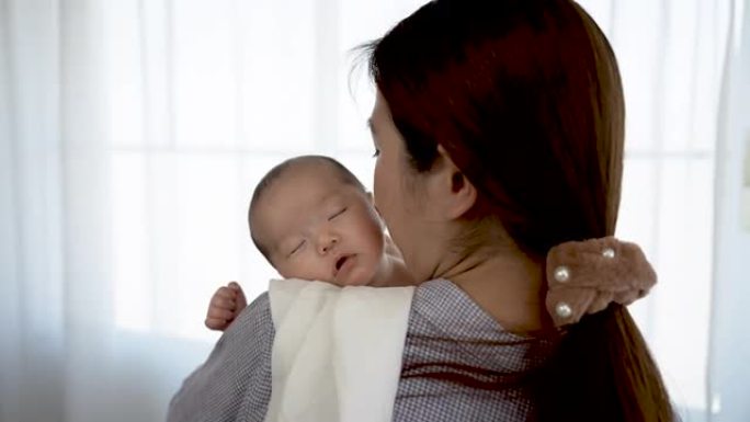 4K 25fps慢动作，母亲抱着婴儿揉了揉头，用温暖哄她睡在她的怀抱中。