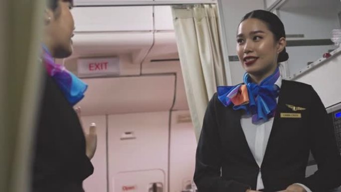 两名亚洲女空姐在飞机上休息时在厨房里一起聊天。食物准备区欢快的空姐