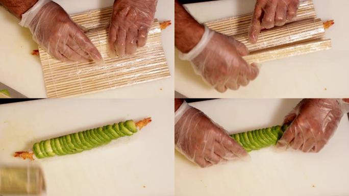 厨师使用竹垫将鳄梨片放在带有虾天妇罗馅的寿司饭上