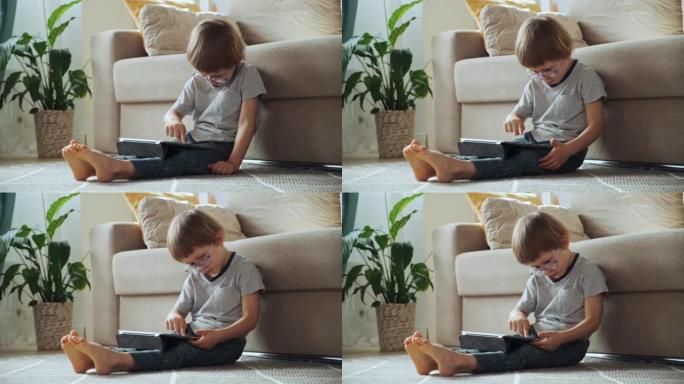 儿童在家中坐在地板上使用平板电脑，远程学习，电子学习，早期儿童发展