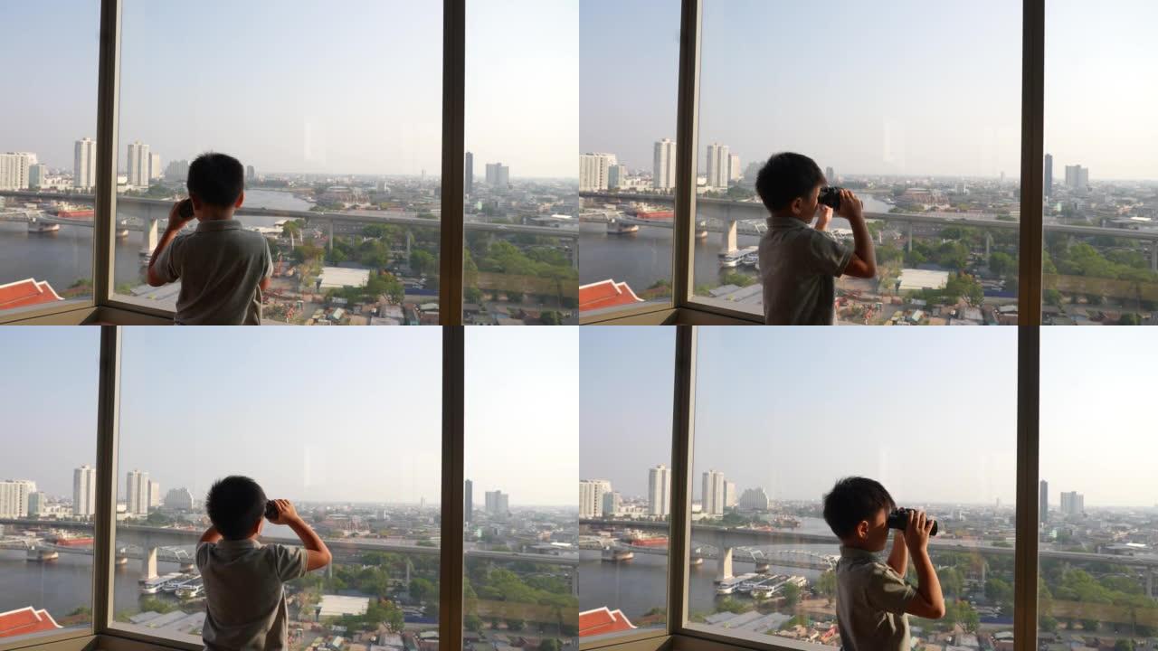 亚洲孩子在曼谷的天际线用双筒望远镜探索。探索和发现的概念
