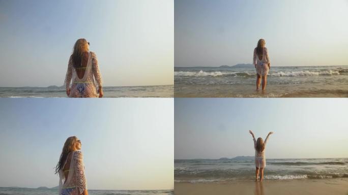 女人在海边的海滩上穿着白色外衣弄湿了头发。戴着太阳镜的金发女郎。游客享受假期，散步很有趣