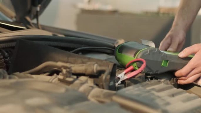 汽车维修工人检查汽车电池电压。在汽车服务站工作的服务工程师