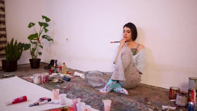 沉思的年轻高加索女艺术家在家庭艺术工作室没有灵感