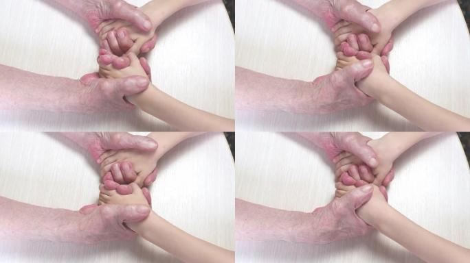 一个老爷爷的手挤压着一个小孩的手。