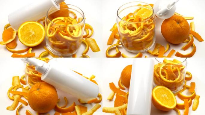 玻璃罐中的新鲜橙皮，新鲜的橙色两半和一个塑料喷雾瓶，自制的天然清洁剂。
