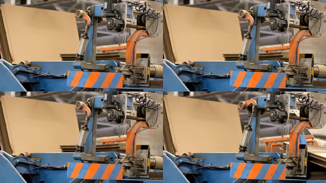 瓦楞纸箱厂。纸板箱的制造。将大包纸板送入机器以生产纸板箱。带声音的镜头。