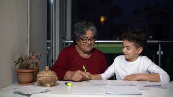 一个小男孩和他的祖母在阳台上做作业的4k视频片段