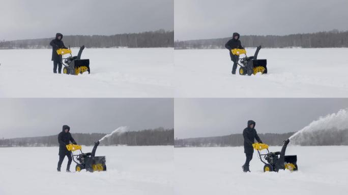 男人在冬天用扫雪机扫雪。侧视图。慢动作