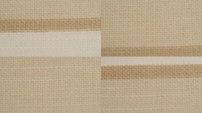 米色条纹面料特写，浅棕色布料纹理背景。棉纺织的宏观拍摄