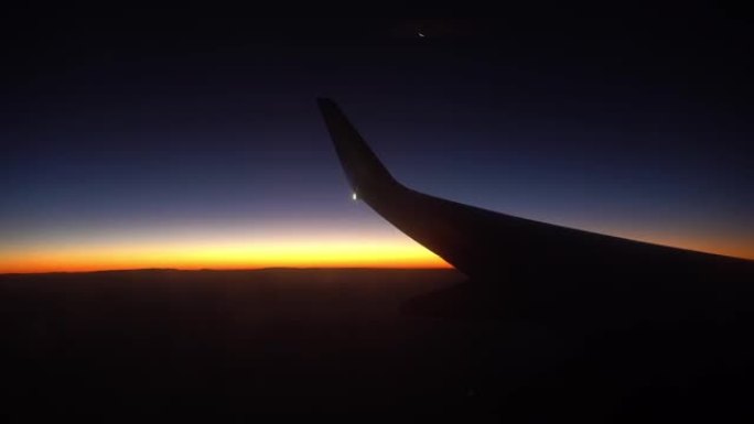 飞机降落在夜空沙漠中，从飞机机翼上的窗户可以看到日出，坠落和飞机坠毁。