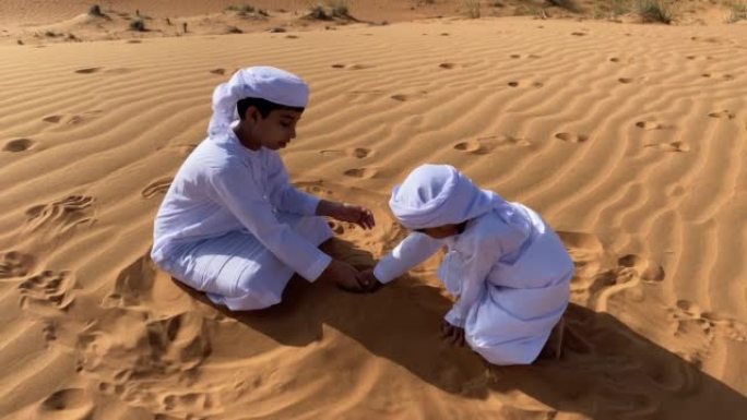 两个在沙漠中玩耍的Emarati孩子