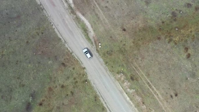 无人机摄像机的航拍视频跟随越野车沿着阿尔泰山区草原景观中的乡间小路行驶
