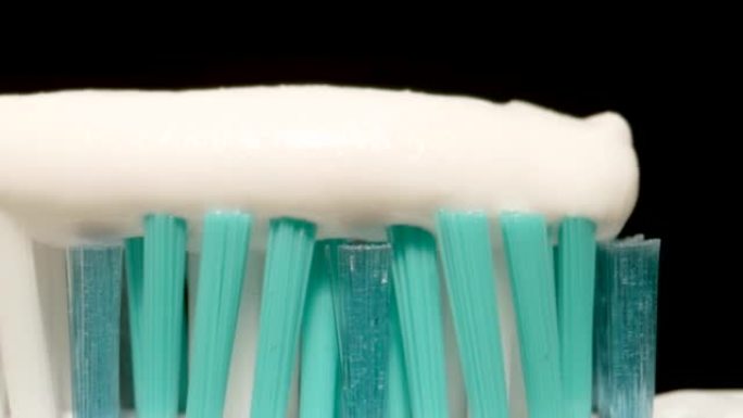 宏观: 黑色背景上的牙刷上的牙膏
