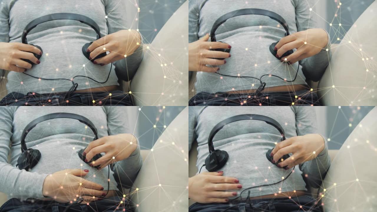 带神经丛颗粒的孕妇在肚子上戴耳机的4k慢动作视频。
