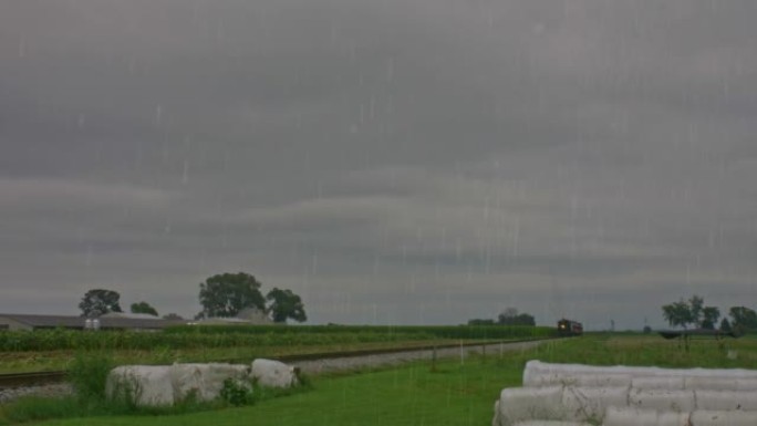 仿古旅客列车吹着浓烟冒雨驶近