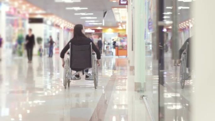 坐轮椅去购物中心的残疾妇女