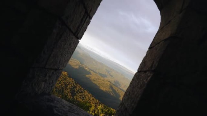 相机飞过一座古塔的跨度，展示着山脉的风景。非常漂亮的镜头