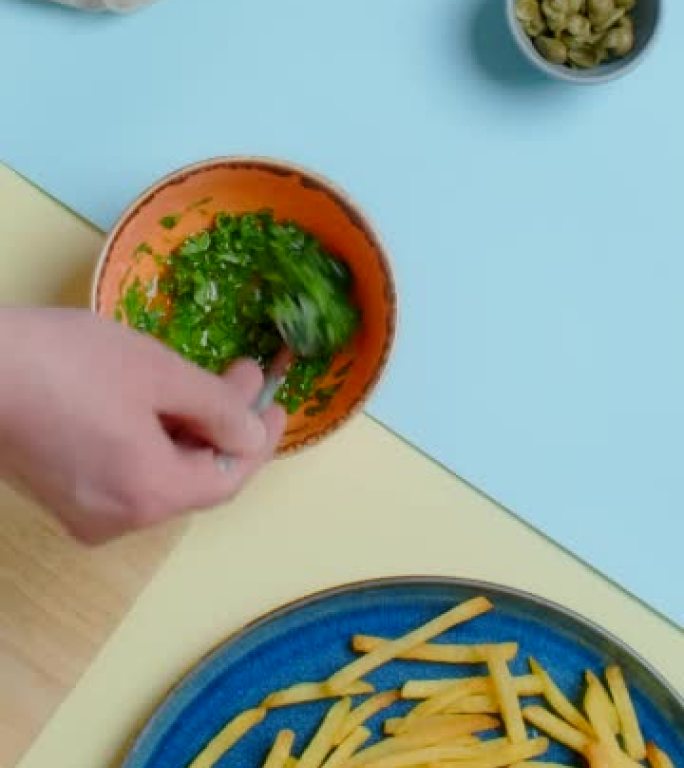 垂直平放视频: 厨师将酱汁和香草混合成炸薯条