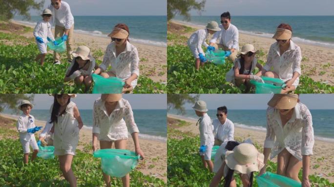 快乐的亚洲家庭与垃圾袋清洁区一起在海滩上。
