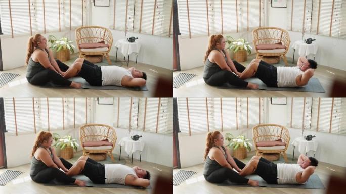 穿着运动服的年轻夫妇一起在家在瑜伽垫上锻炼