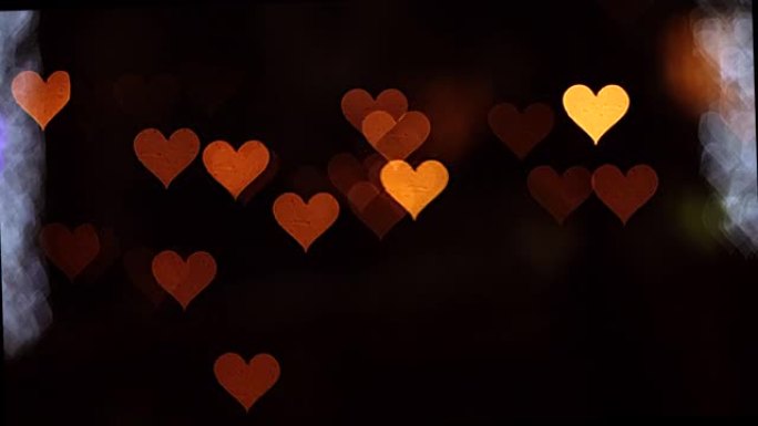 情人节4K UHD视频背景。黑色背景上浪漫闪耀、闪烁的心的波克。爱，心状的波克。