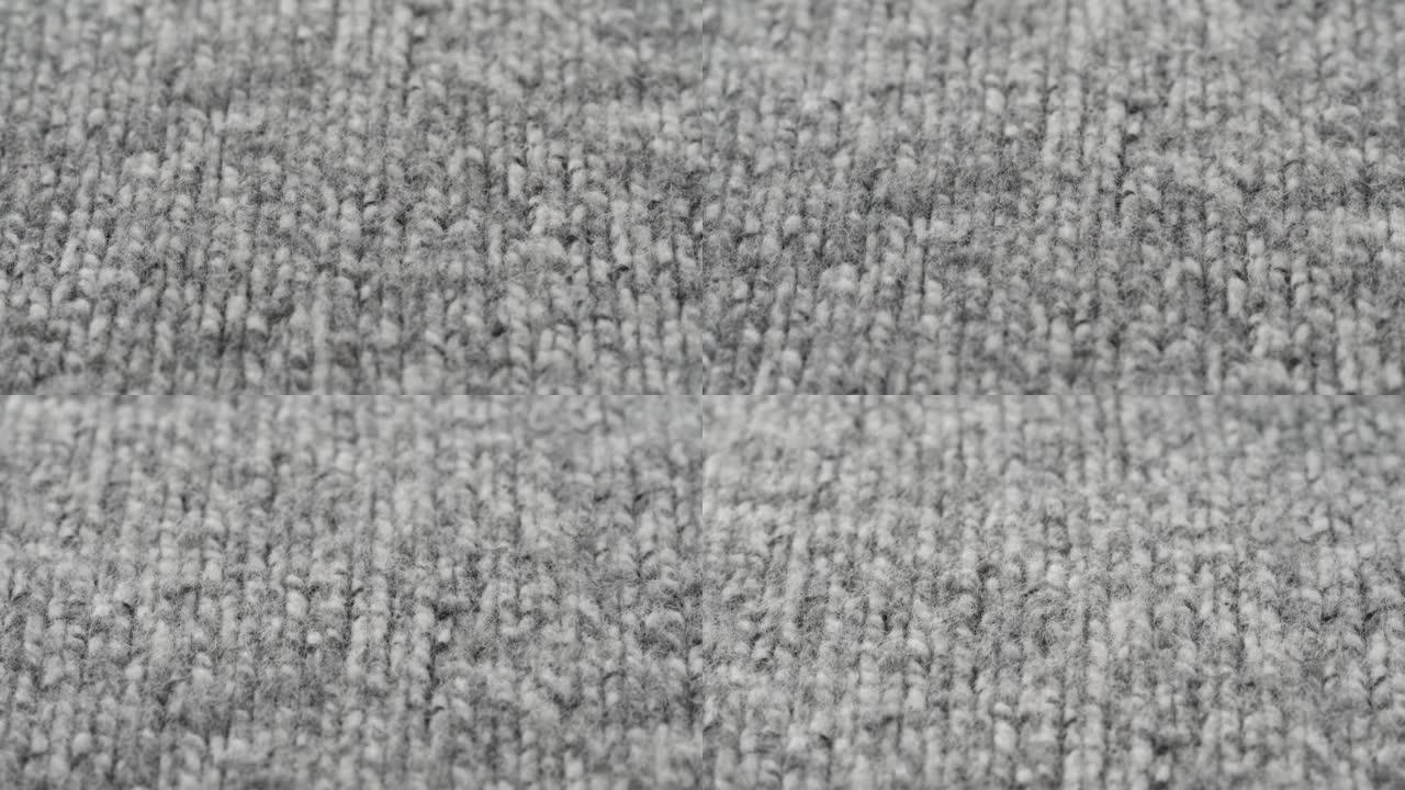 灰色羊毛面料特写。柔软保暖针织布的微距拍摄。羊毛服装，抽象背景。剪裁和缝纫概念。材料样品