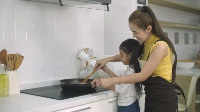 年轻女孩在家帮助母亲做饭