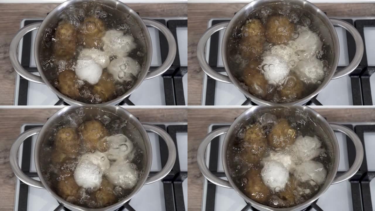 生的白鸡蛋和土豆在厨房的煤气炉上的平底锅中用沸水煮沸。特写。顶视图。烹饪健康食品的概念。4K。